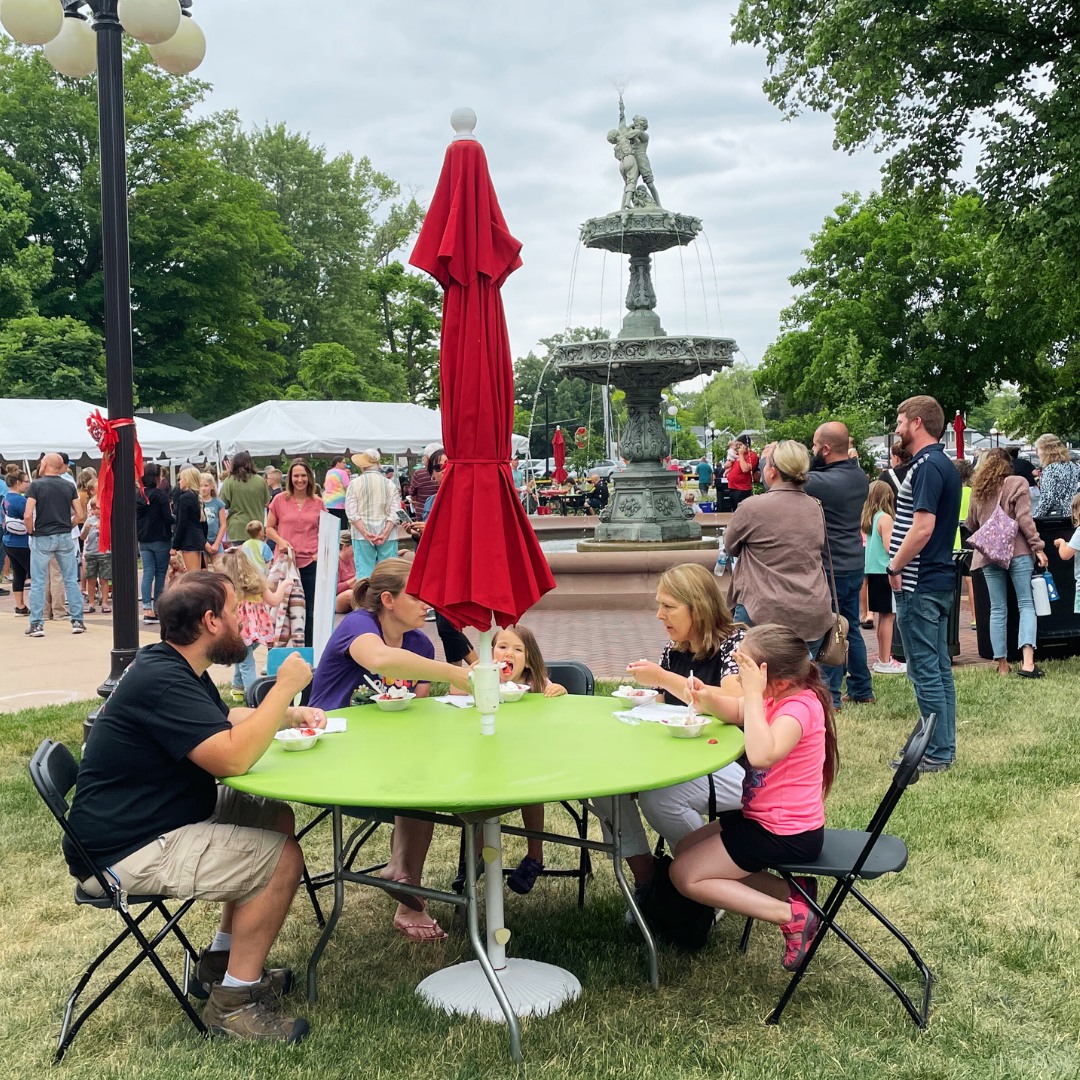 Picture of people enjoying strawberry shortcake in the library park.